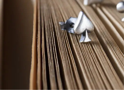 Pik Ohrstecker liegen auf einem Buch